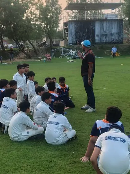 A coach leads a group discussion with our junior players. It is important to develop their thinking about the game, not just their physical skills.