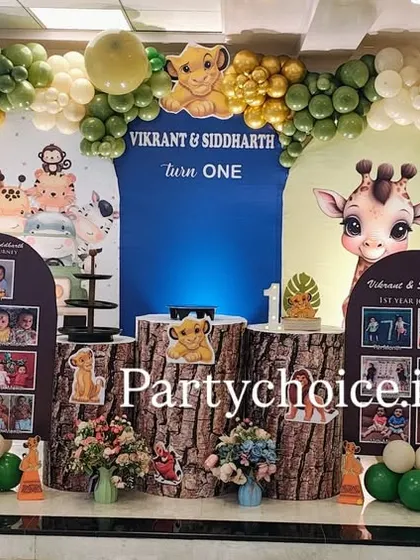 A wide view of the jungle theme stage, showcasing the arrangement of character cutouts, photo displays, and the impressive balloon arch that frames the entire setup.