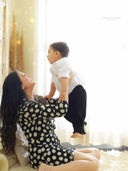 The pure joy of a mother playing with her child. This candid moment, captured in our studio, perfectly shows the loving and playful bond they share.