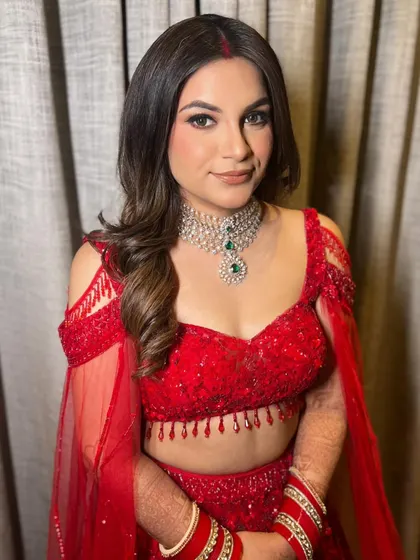 The complete bridal look, with the red lehenga and soft waves, is a perfect combination of tradition and modern elegance.