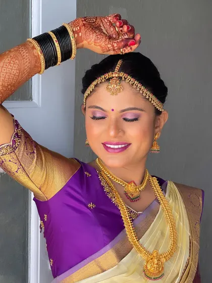 This pose showcases the intricate henna design on her hands, along with her flawless makeup and traditional jewellery.