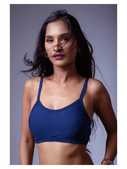 A strong and moody portrait in a sports bra. The lighting sculpts the model's features, creating a powerful and athletic look.
