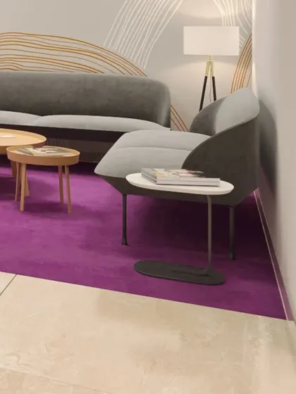 The client waiting lounge, furnished with contemporary seating and a bold purple area rug that adds a vibrant pop of color to the neutral palette.
