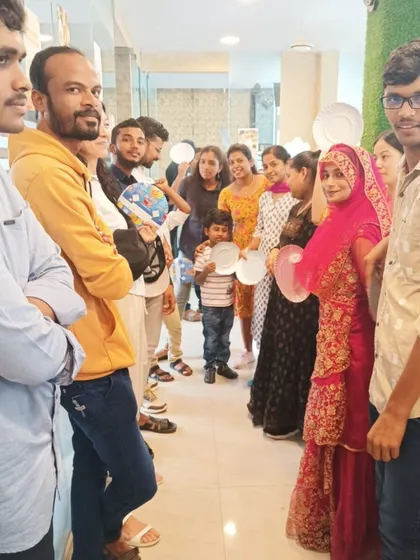 Students lining up for a fun game during a potluck event. We integrate interactive activities into our community gatherings to make practicing English feel natural and enjoyable.