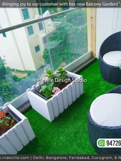 A high-angle shot of the balcony's seating area and planters. The design makes efficient use of the compact space, creating a lush and comfortable nook.