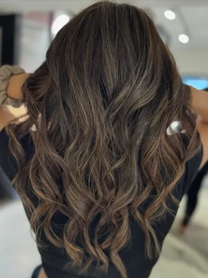 Here, we transitioned from a warmer color to this cool beige balayage. The new tones and fresh haircut work together to create a sophisticated and modern look.