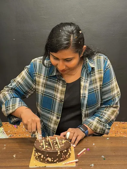 The birthday girl cutting her cake. These celebrations are a huge part of our studio's community spirit.