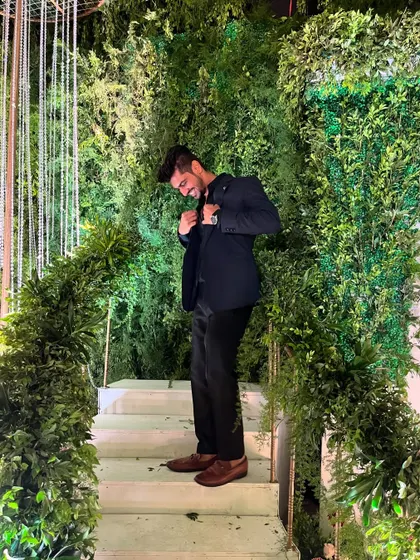 A stylish pose on a greenery-covered staircase at a wedding venue. I always dress to match the elegance of the event.