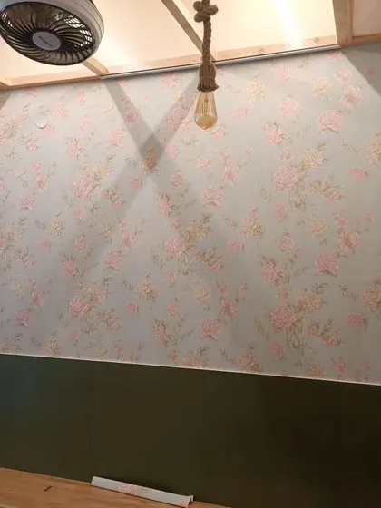 A wall with a vintage-style floral wallpaper in soft pastel colors. The design is perfect for creating a shabby-chic or romantic look.