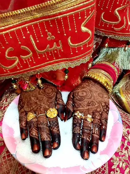 The rich stain on a bride's hands, perfectly accessorized with rings and bangles for her wedding day.