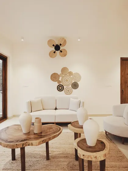 Another living space in the villa continues the theme of natural elegance. A live-edge coffee table and side tables made from tree stumps are paired with a clean-lined sofa, showcasing a beautiful balance of rustic and modern design.