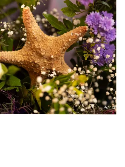 A close-up shot of a starfish nestled in a floral arrangement. This small detail beautifully merges the underwater theme with elegant floral decor.
