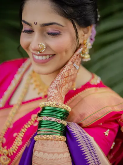 Happiness looks gorgeous on her. This image showcases the complete look, from the elegant updo and chandrakor to the layers of gold jewelry and the perfectly draped saree.