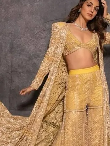 Kiara Advani's yellow sharara set with a long jacket is a stunning choice for a mehendi. I can create a similar vibrant, three-piece set for your pre-wedding festivities.