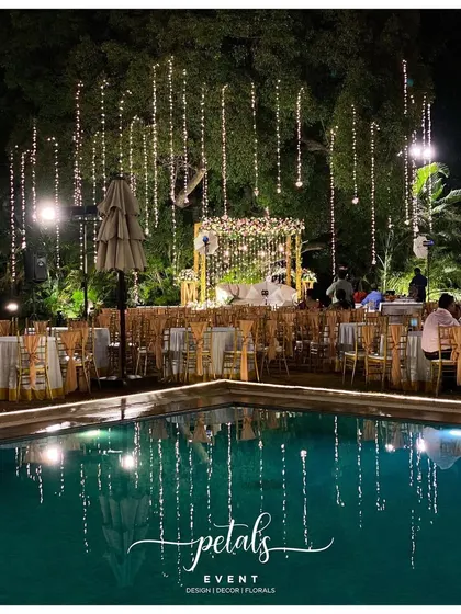 The reception decor at The Lalit Ashok Bangalore is a symphony of flowers and lights. The vibrant floral arrangements are reflected in the tranquil pool, creating a truly captivating and magical scene.