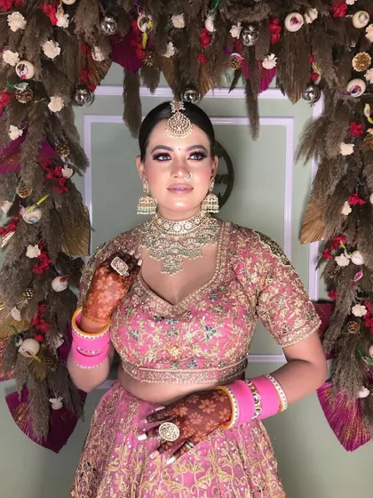 This bride looks absolutely lovely in her pink lehenga. I provided the full styling, including makeup that complements her outfit and henna that adds a touch of tradition.