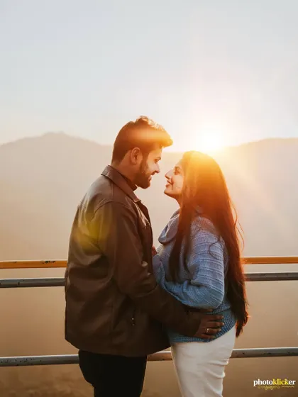 A classic golden hour portrait of a couple, with the setting sun creating a beautiful flare between them as they gaze at each other.
