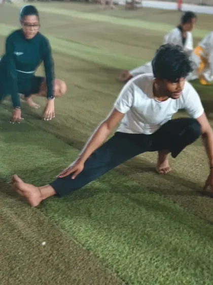 A student performs a deep stretch, working on his hamstring flexibility. This is crucial for preventing injuries and executing high kicks.
