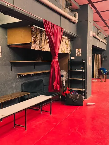 We provide all the necessary amenities for our players, including seating areas for rest and observation. You can see a player warming up in the background, getting ready for a session.