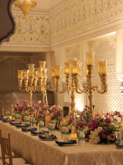 Another look at the long banquet table, showcasing the intricate lace linen, the line of golden candelabras, and the abundant floral runner. The design was all about creating a feeling of timeless elegance and opulence.