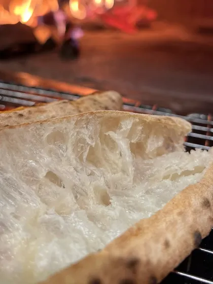 Tearing open the crust to reveal the soft, steamy interior. This is the texture we're obsessed with.