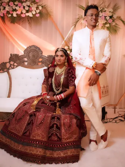 A classic wedding portrait of the couple seated on the stage, looking like royalty.
