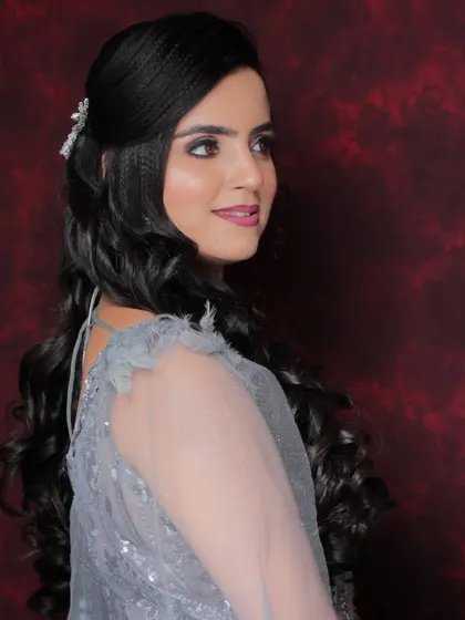 A side view of the party look, showing the soft curls and the way the makeup enhances her profile. A perfect look for photos.