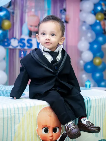 A fun "Boss Baby" themed birthday shoot. The birthday boy sits confidently on a themed table, perfectly capturing the playful spirit of the popular character.