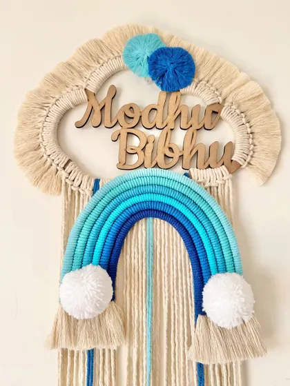 This name hanging for Madhav and Bibhu was customized with a beautiful blue ombre rainbow and matching blue pom-poms.