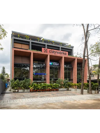The completed Clayworks building in Koramangala, featuring a robust brick facade that adds warmth and texture to the urban streetscape. The deep-set windows and strong vertical lines create a powerful architectural statement.