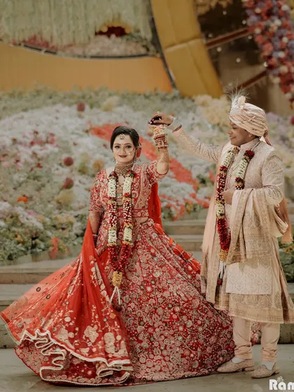 A dynamic and joyful shot of the couple on stage, with the bride twirling, her lehenga in full motion.