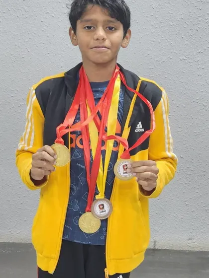 Aadeshwar displays the multiple gold medals he won at the Splash N' Dash competition in freestyle, butterfly, and breaststroke events.