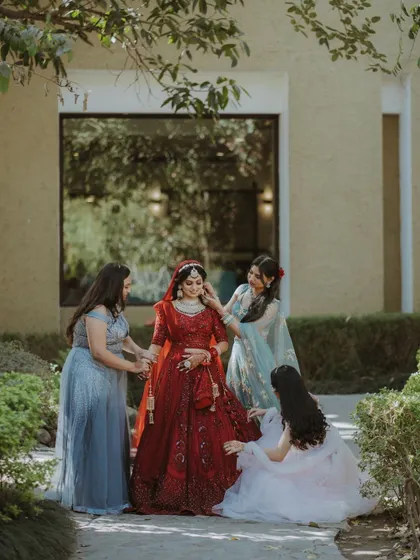 A bride being attended to by her bridesmaids. This is a beautiful, candid moment of friendship and support in the final minutes before the ceremony.