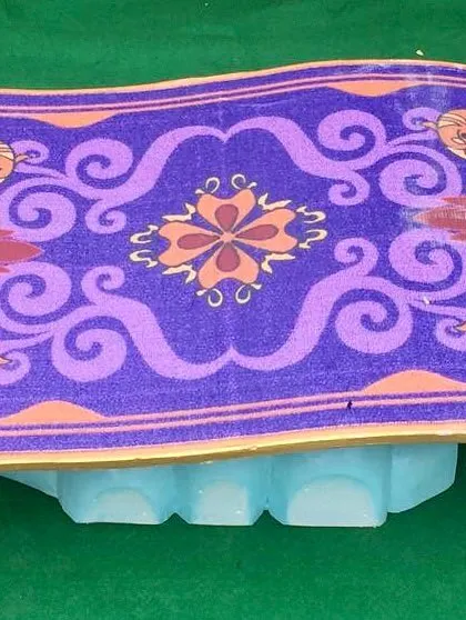 A close-up of our custom-made magic carpet prop, designed to look like it's floating on a cloud. It's the perfect stand for a special birthday cake.