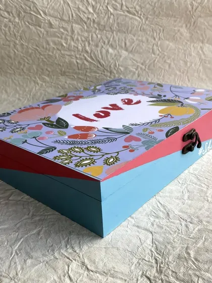This personalized jewelry box for a bride features a lovely floral design and pastel colors, with the word "love" at the center.