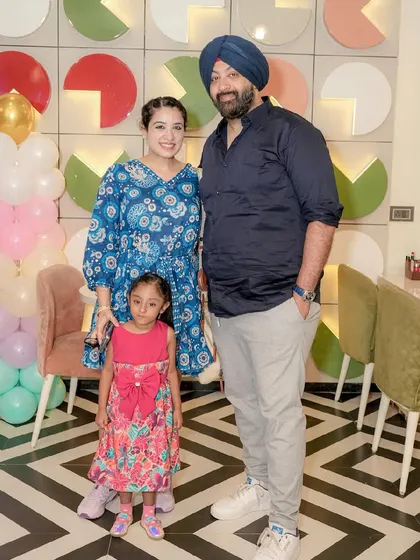 A family poses for a photo in front of our signature logo wall.