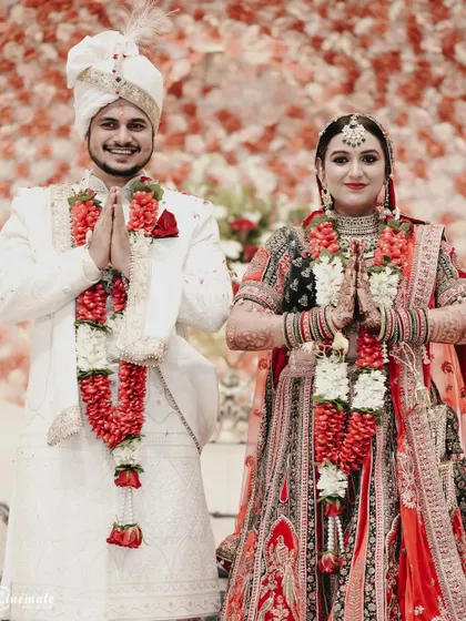 The couple greets their guests with a respectful 'Namaste'. A beautiful portrait reflecting tradition and gratitude.