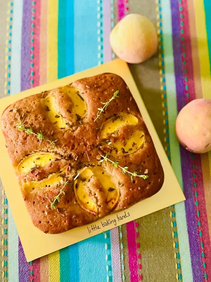 A square peach and thyme cake, made with whole wheat. The savoury note of thyme pairs beautifully with the sweet peaches.