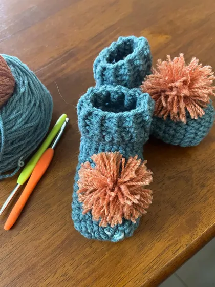 Here are the pom-pom booties next to the yarn and hooks I used to make them. It's amazing to see how a few simple tools can create something so lovely.