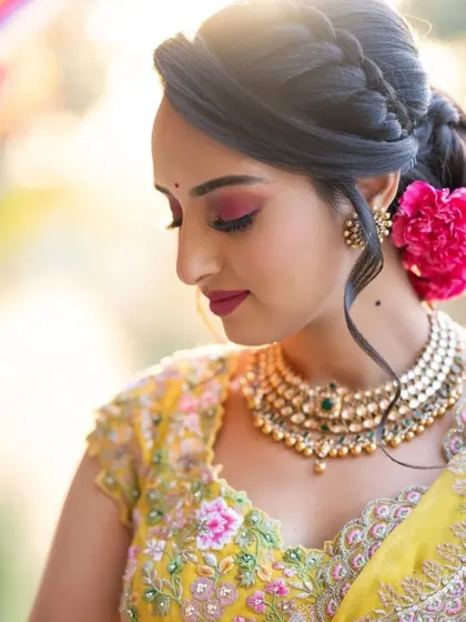 A close-up of the bride's Haldi makeup, showing the beautiful pink eyeshadow and the fresh flower in her hair.