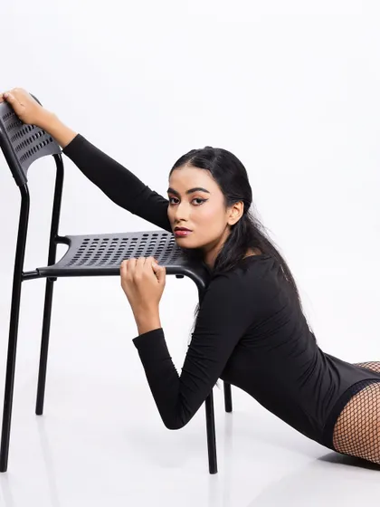 A dynamic pose with a chair, showcasing the model's strength and flexibility.