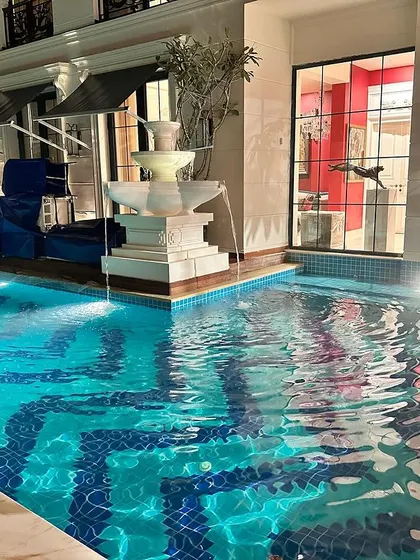The combination of the flowing water from the fountain and the shimmering pool surface adds life and movement to the space.