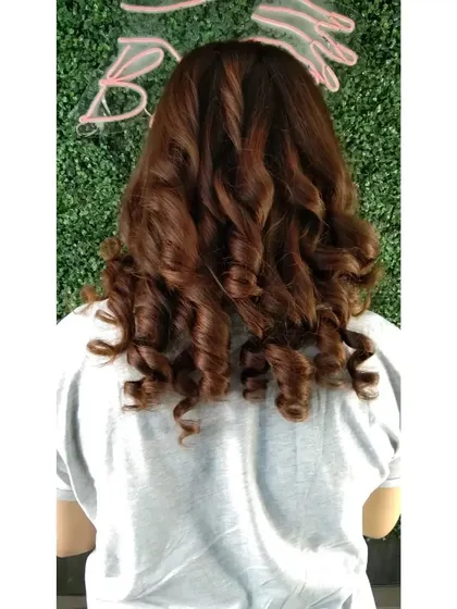 A deep, rich brunette global color styled with bouncy curls. This shows how a single, well-executed color can look stunning and luxurious.