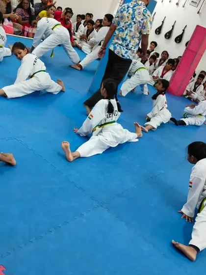 A high-angle view of the class during stretching, showing their synchronized effort.