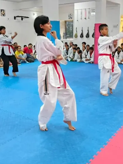 A student practices her form, which includes various kicks.