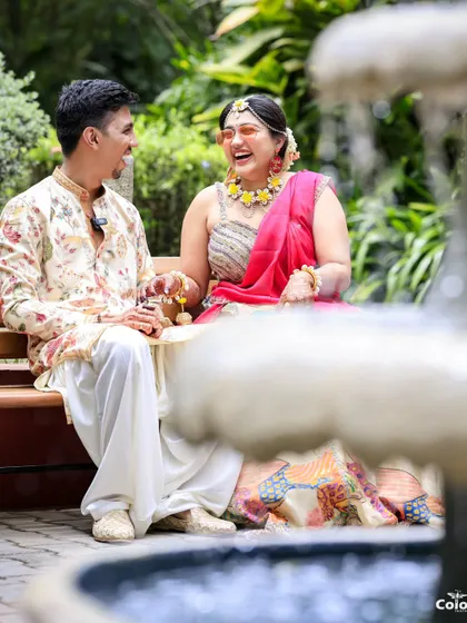 A candid photo of the couple sharing a laugh by a fountain during their Mehendi ceremony. These natural interactions make for the best pictures.