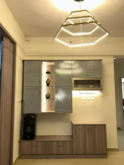 A close-up of the vintage-modern crockery unit, showing the combination of grey cabinets and wood-finish lower storage. The integrated lighting adds a warm, inviting glow.