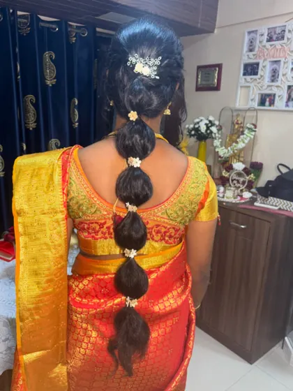 A modern take on a traditional South Indian braid. This bubble braid is decorated with flowers and is a great option for long hair.
