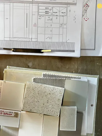 A glimpse of the organized chaos on site. Material samples for a bathroom in the 58WV project are laid out next to the architectural drawings, showing the bridge between plan and physical material.