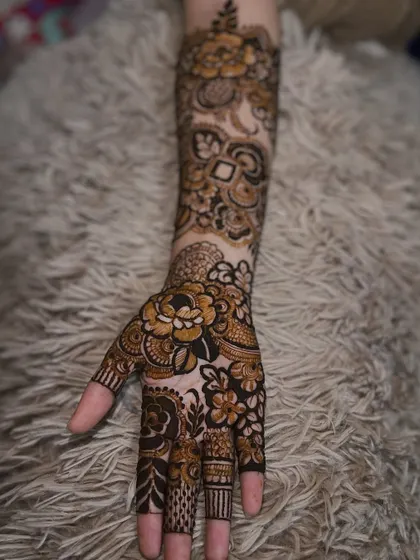 A single hand view of the engagement floral design, showing the detailed work on the palm and fingers.